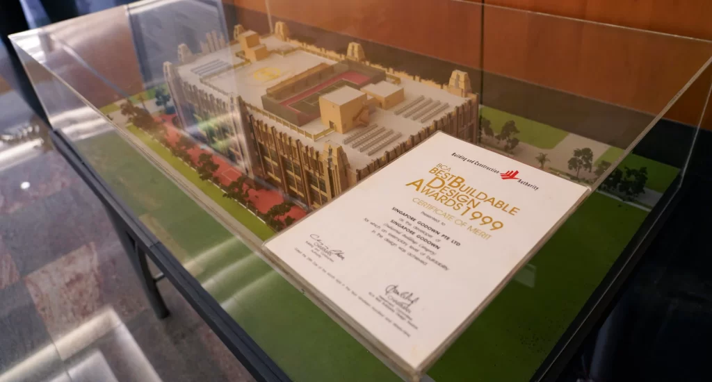 BCA Buildable Design Award certification, awarded in 1999, displayed on glass showcase of the Singapore G building model