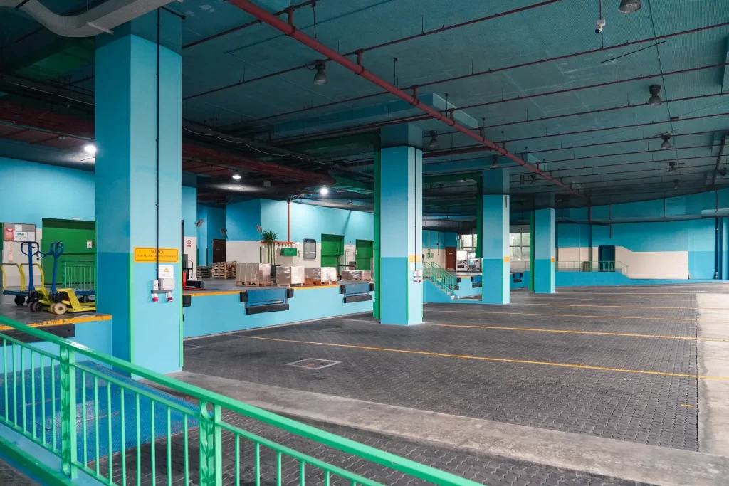 Spacious sheltered loading bay at the back of building, with 8 bays all with dock levellers and 4 bays with power outlets for charging of freezer or chiller containers